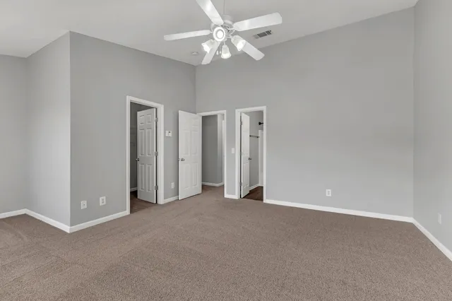 a view of an empty room with a ceiling fan