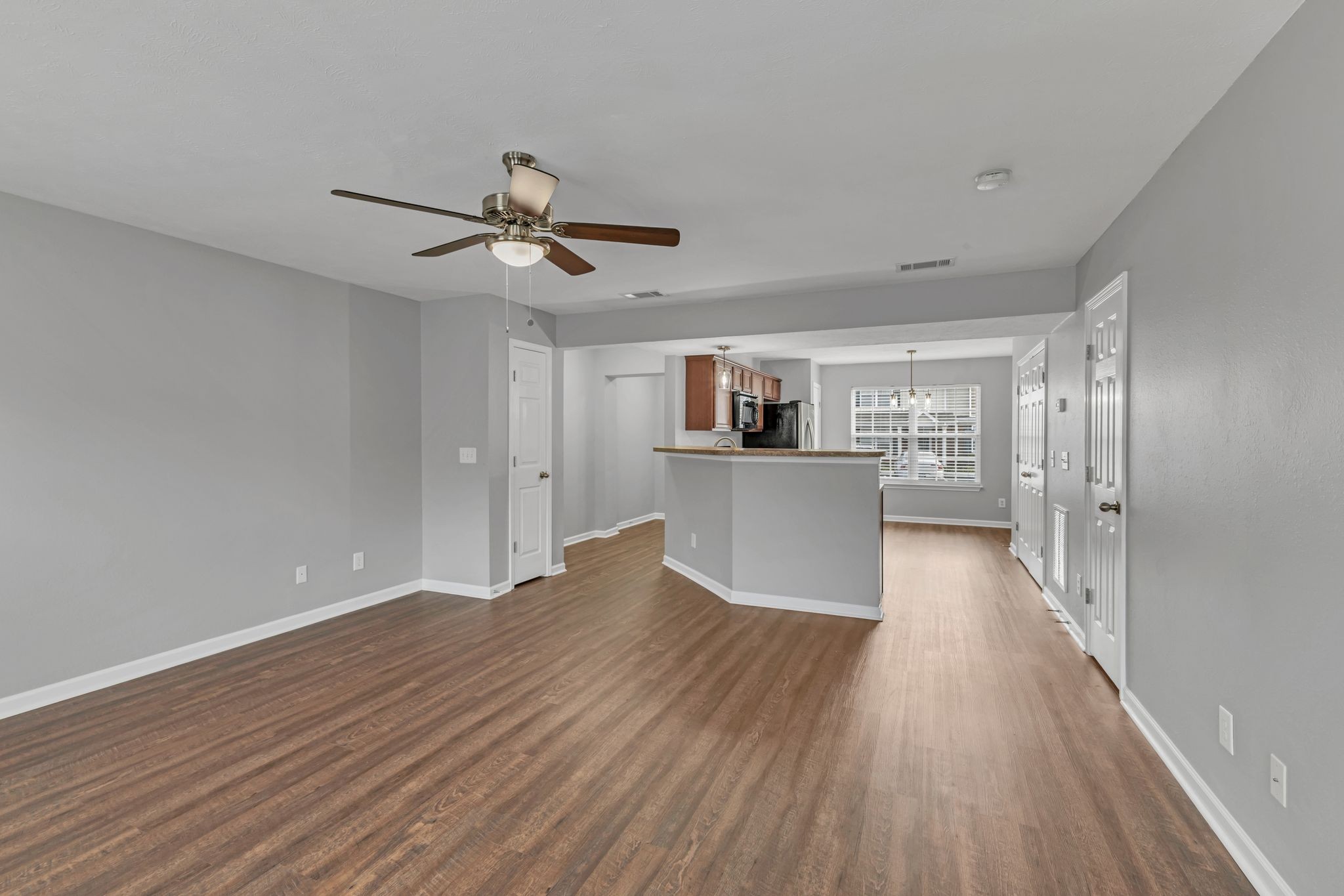 2011 Shaylin Loop, Unit 2011 Antioch, TN 37013 - Photo 8 of 26 a view of a kitchen and an empty room with wooden floor and a kitchen