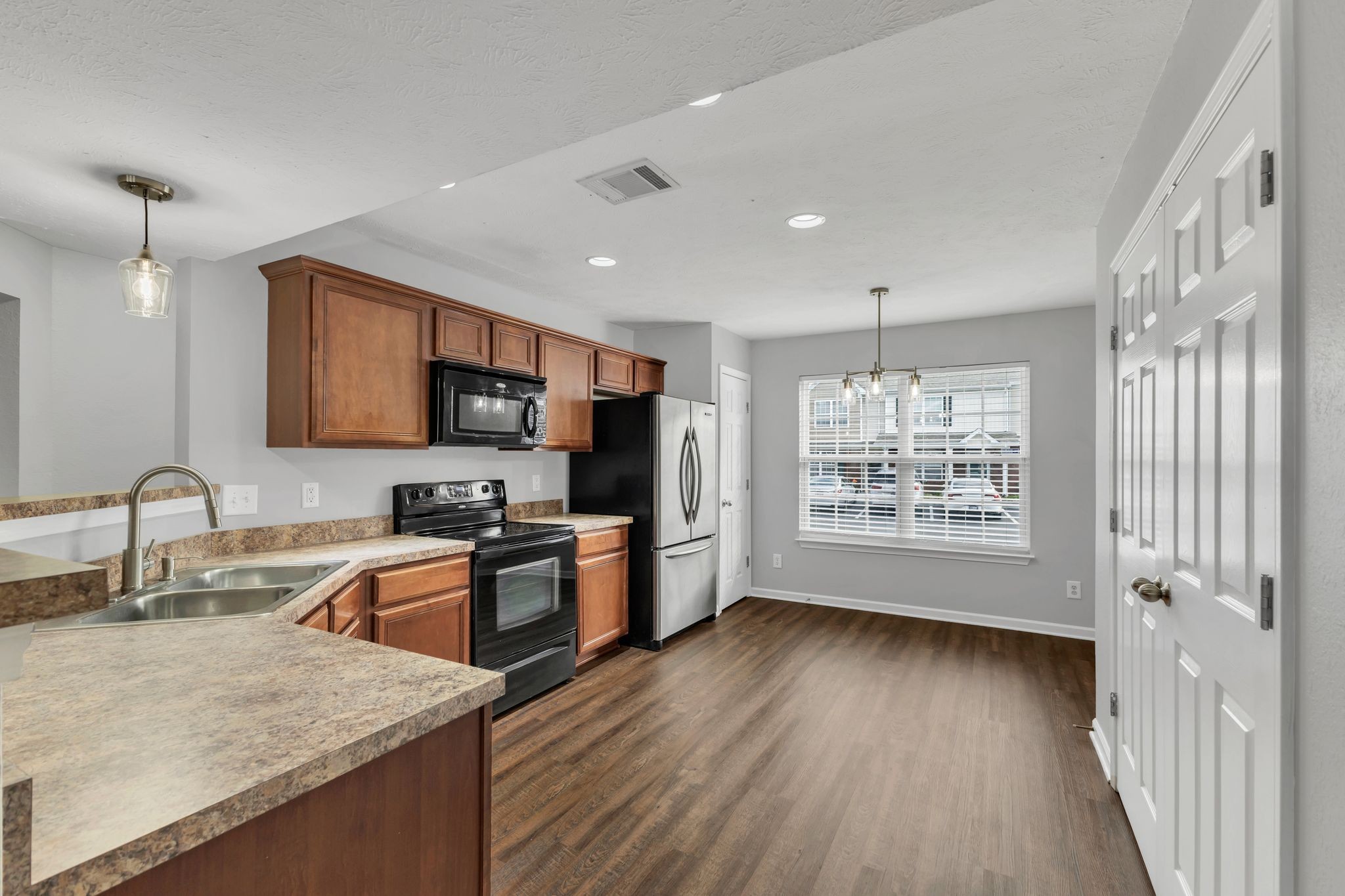 2011 Shaylin Loop, Unit 2011 Antioch, TN 37013 - Photo 9 of 26 a kitchen with stainless steel appliances granite countertop wooden cabinets a refrigerator a sink a stove a microwave and wooden floors