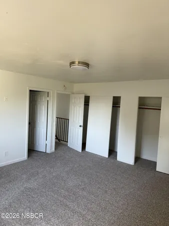 a view of empty room with wooden floor and fireplace