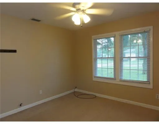 an empty room with a window and a fan