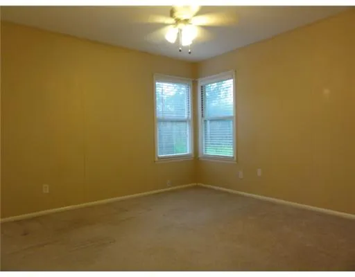 en empty room with windows and chandelier fan
