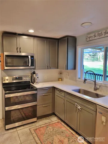 a kitchen with stainless steel appliances granite countertop a sink and a stove