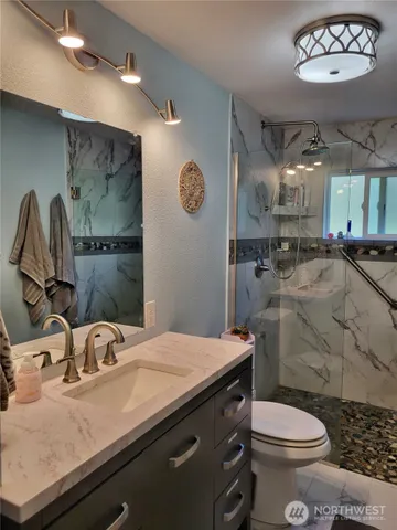 a bathroom with a sink a toilet and a mirror