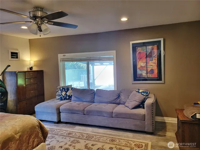 a spacious bedroom with a bed a couch and a chandelier