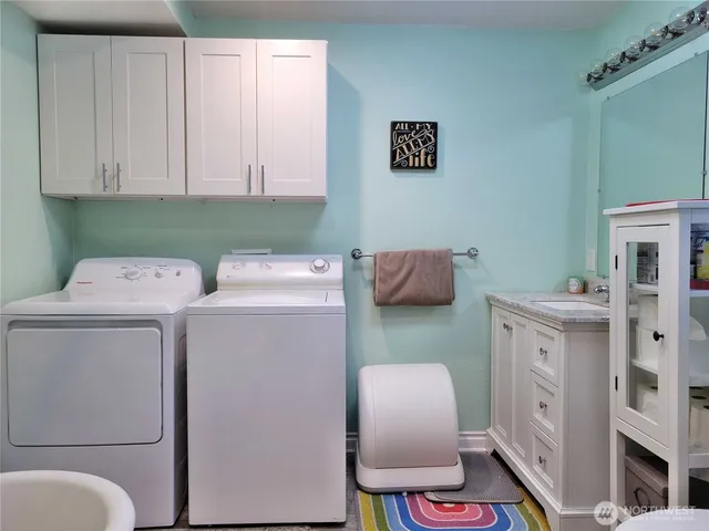 a utility room with dryer washer and a view of living room