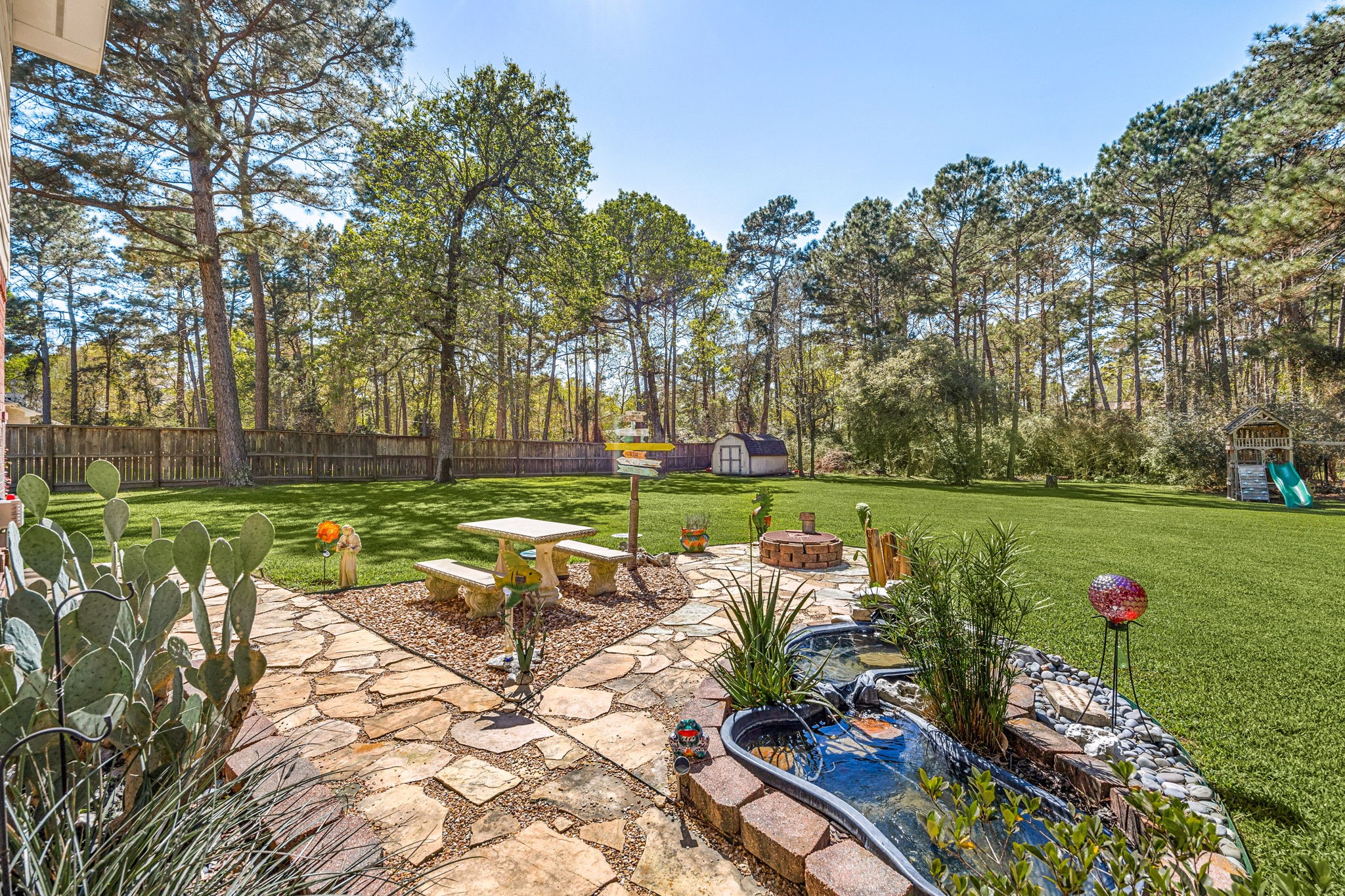 14419 Timbergreen Drive Magnolia, TX 77355 - Photo 32 of 43 Enjoy outdoor living in this spacious backyard with stone patio, decorative garden area, and plenty of room for entertaining or relaxing in a private setting.