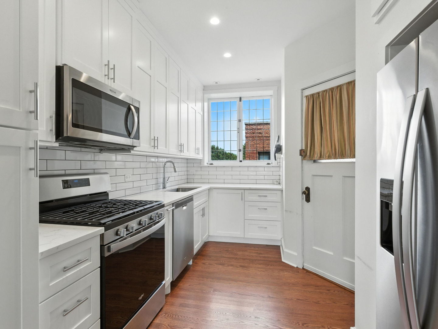 1368 East 57th Street, Unit 3 Chicago, IL 60637 - Photo 6 of 12 a kitchen with stainless steel appliances a stove microwave and refrigerator