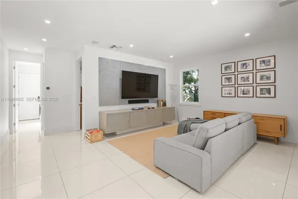 a living room with furniture and a wooden floor