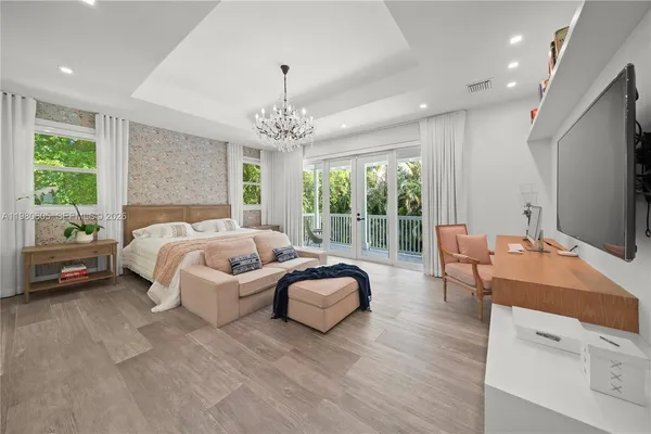 a bedroom with a bed a table and a large window