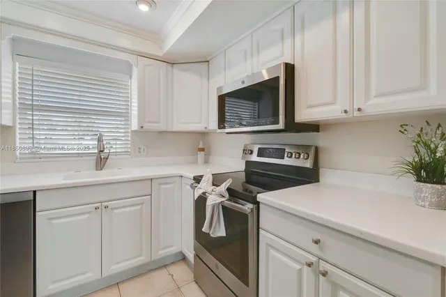 a kitchen with white cabinets and white appliances