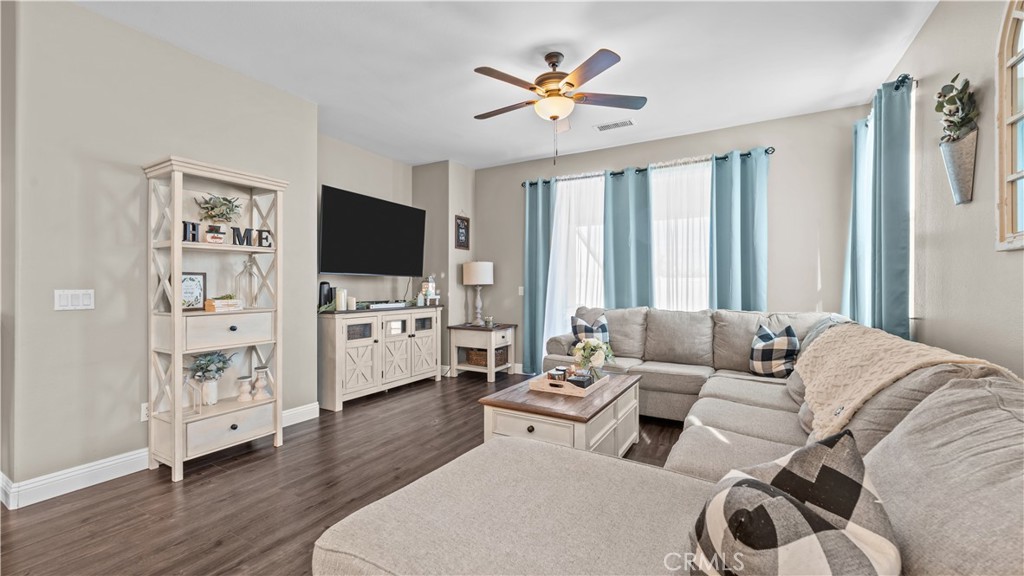 11780 Poppy Road Adelanto, CA 92301 - Photo 12 of 35 a living room with furniture a ceiling fan and a flat screen tv