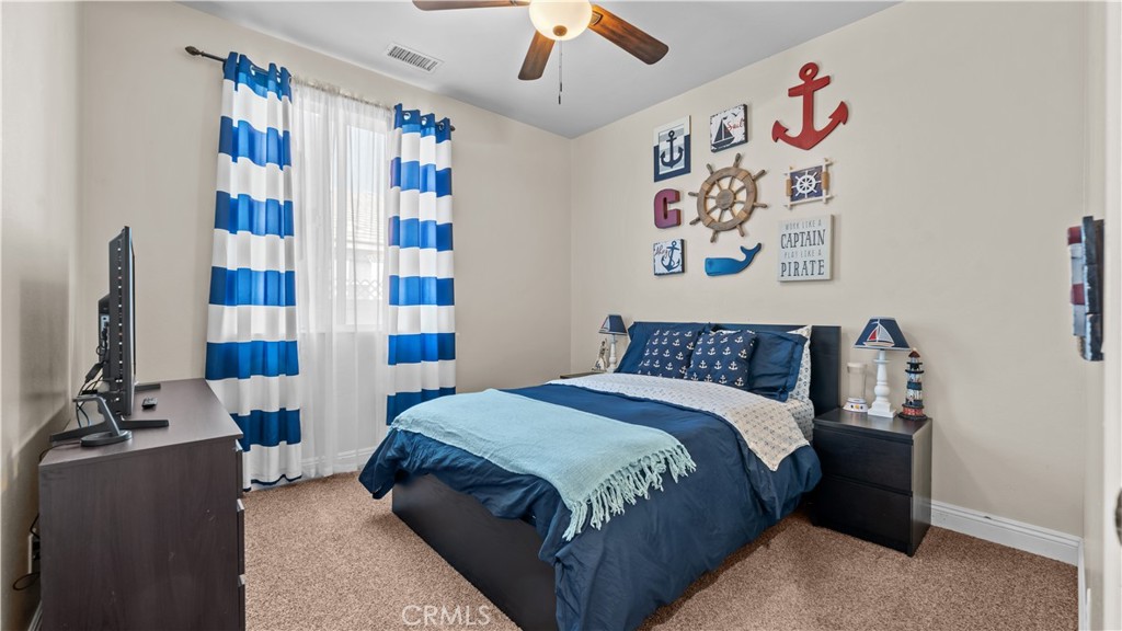 11780 Poppy Road Adelanto, CA 92301 - Photo 17 of 35 a bedroom with bed and book shelf