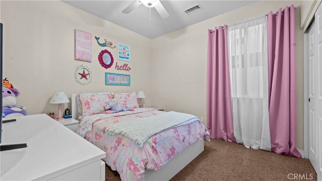 11780 Poppy Road Adelanto, CA 92301 - Photo 19 of 35 a bedroom with a bed and a chandelier