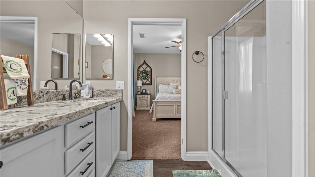 11780 Poppy Road Adelanto, CA 92301 - Photo 23 of 35 a en suite bathroom with a granite countertop sink mirror and shower