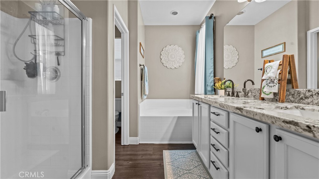 11780 Poppy Road Adelanto, CA 92301 - Photo 24 of 35 a bathroom with a granite countertop sink a mirror and a bathtub