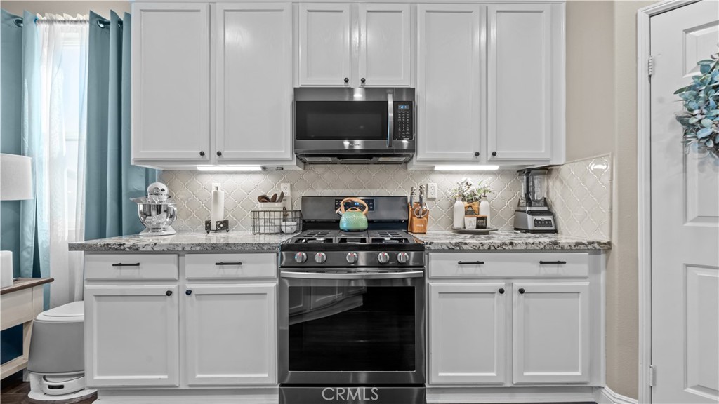 11780 Poppy Road Adelanto, CA 92301 - Photo 8 of 35 a kitchen with white cabinets and appliances