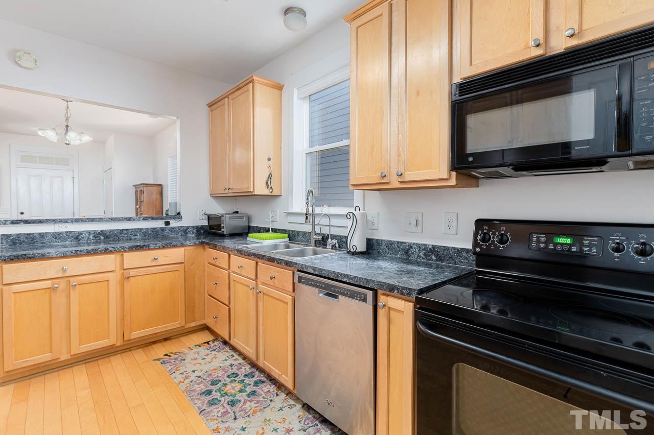 2813 Falls River Avenue Raleigh, NC 27614 - Photo 9 of 28 a kitchen with stainless steel appliances granite countertop a stove a sink and a microwave