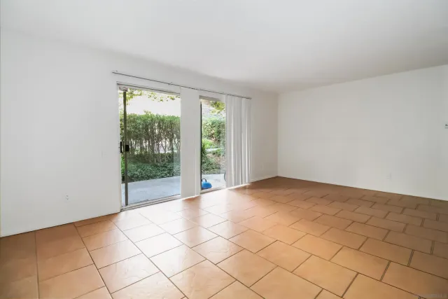 a view of a kitchen with a sink and an empty room