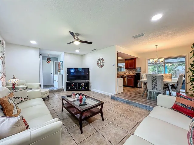 a view of a dining room and livingroom with furniture wooden floor a chandelier