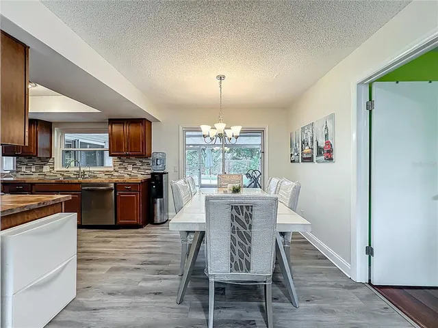 a kitchen with stainless steel appliances granite countertop a stove top oven a sink dishwasher and wooden cabinets with wooden floor