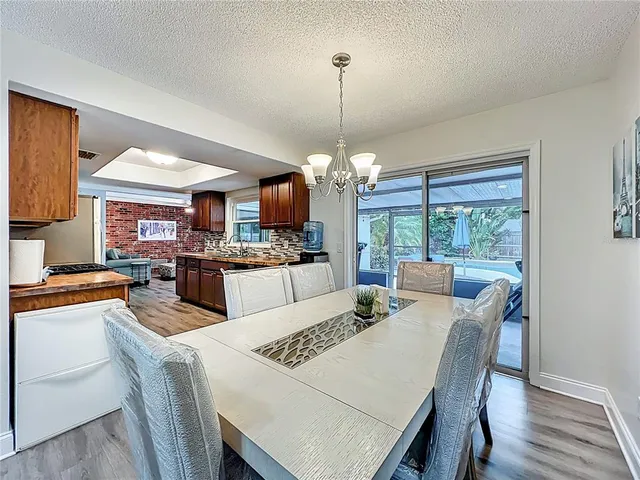 a kitchen with stainless steel appliances granite countertop a stove top oven a sink dishwasher a microwave oven and a refrigerator with wooden floor