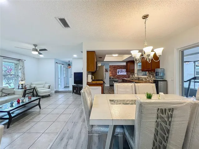 a kitchen with stainless steel appliances granite countertop a stove top oven a sink dishwasher a refrigerator and cabinets with wooden floor