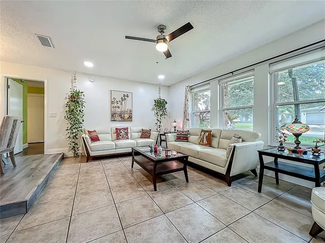 a kitchen with a refrigerator a stove top oven a sink dishwasher and dining table with wooden floor