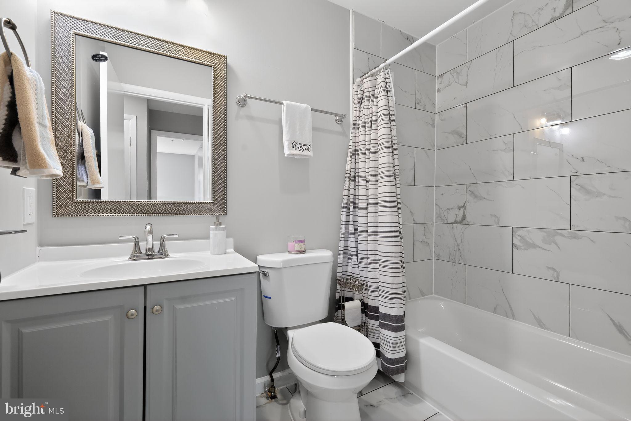 7804 Guildberry Court, Unit 202 Gaithersburg, MD 20879 - Photo 13 of 19 a bathroom with a sink toilet and shower