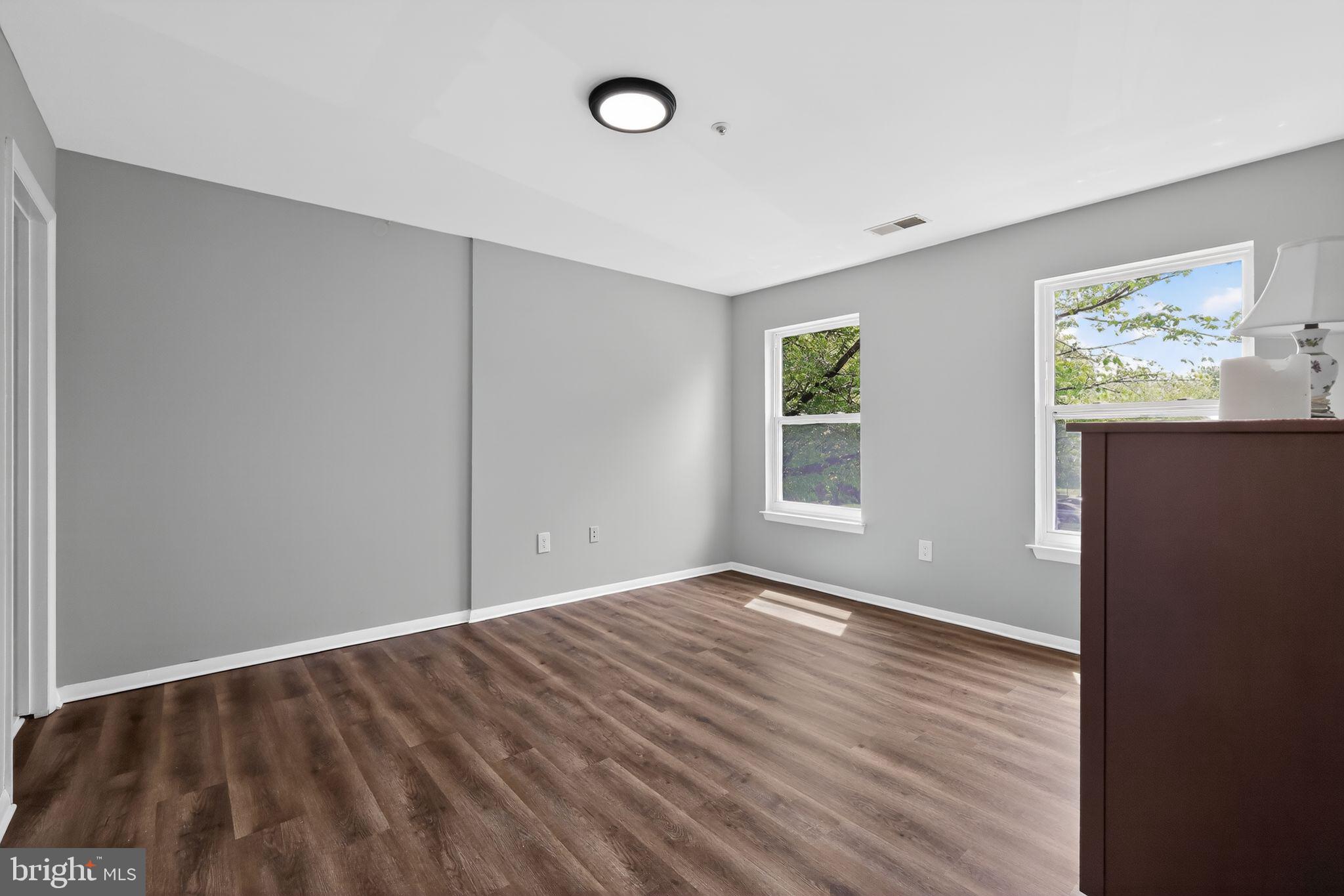 7804 Guildberry Court, Unit 202 Gaithersburg, MD 20879 - Photo 14 of 19 a view of an empty room with wooden floor and a window