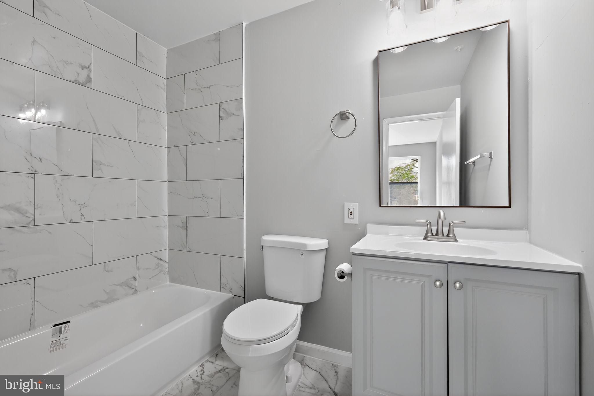 7804 Guildberry Court, Unit 202 Gaithersburg, MD 20879 - Photo 16 of 19 a bathroom with a sink a toilet and shower