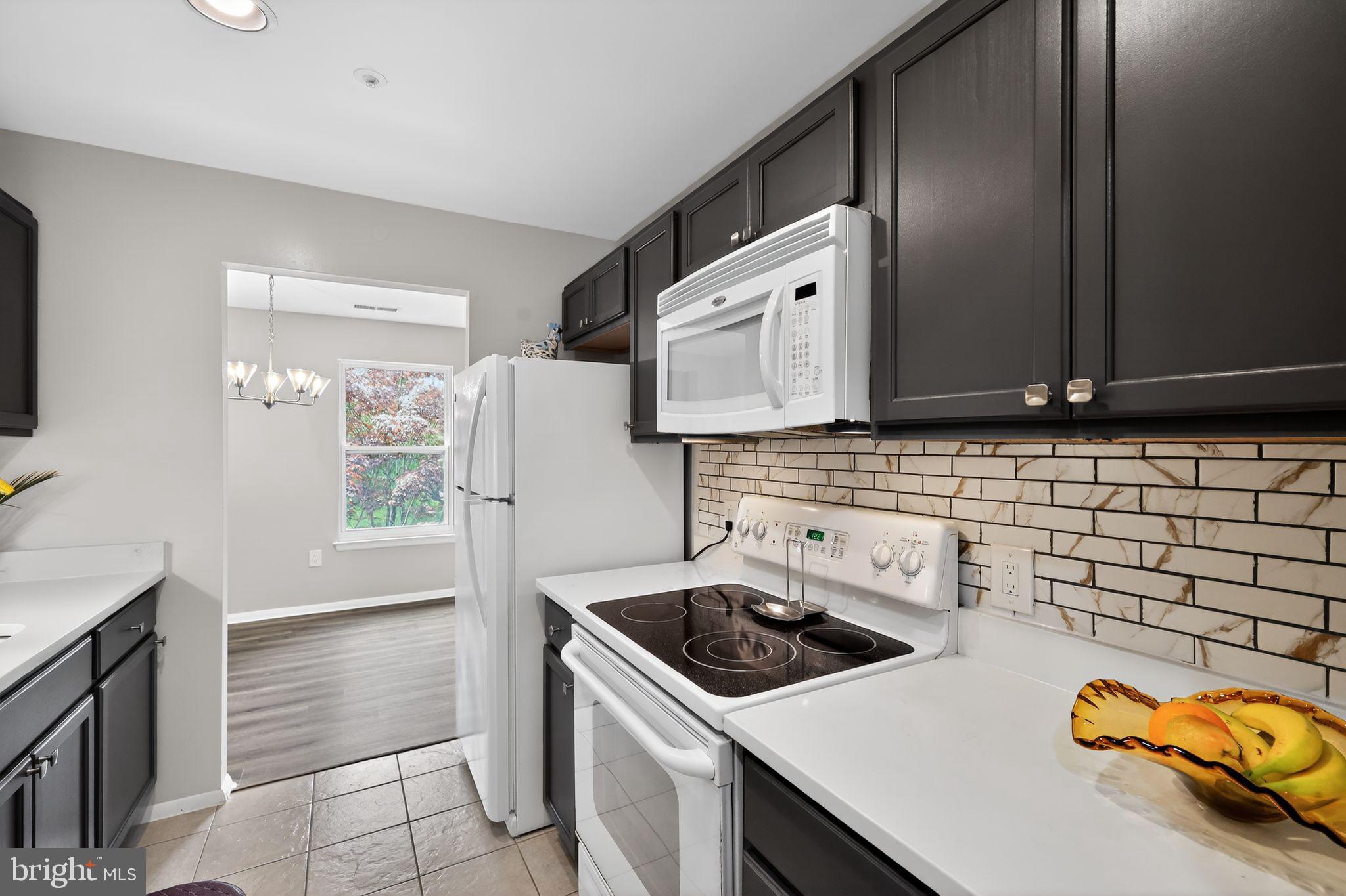7804 Guildberry Court, Unit 202 Gaithersburg, MD 20879 - Photo 2 of 19 a kitchen with a sink a stove and a refrigerator
