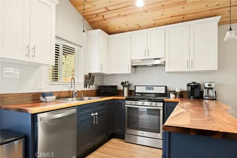 a kitchen with stainless steel appliances granite countertop a sink a stove and cabinets