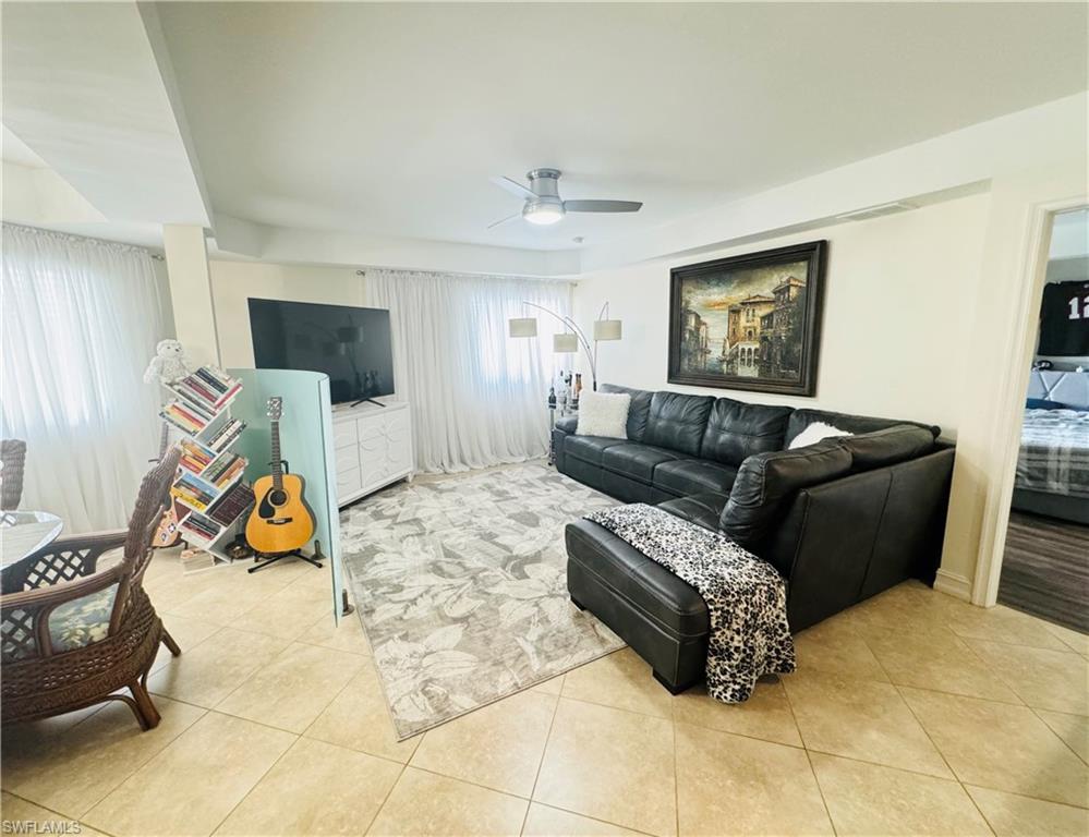 Tiled living room featuring ceiling fan and plenty of natural light