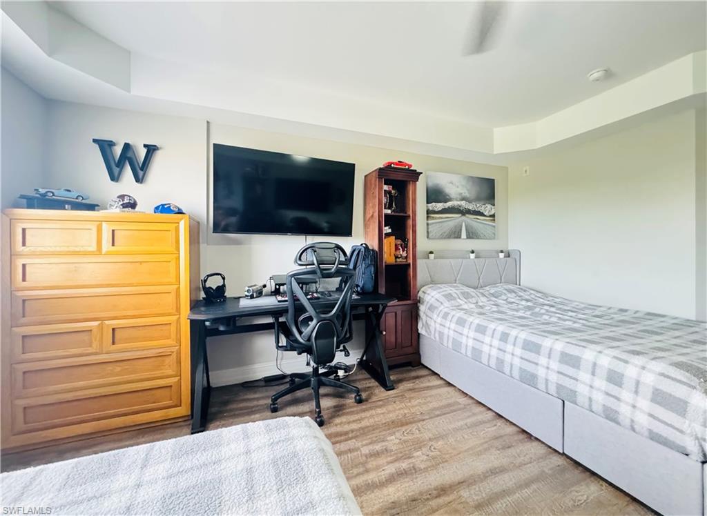 1100 Pine Ridge Road, Unit 401B Naples, FL 34108 - Photo 8 of 11 Bedroom with wood-type flooring and a raised ceiling