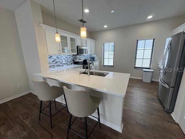 906 Pawstand Road Celebration, FL 34747 - Photo 12 of 29 a kitchen with stainless steel appliances a dining table chairs in it and wooden floors