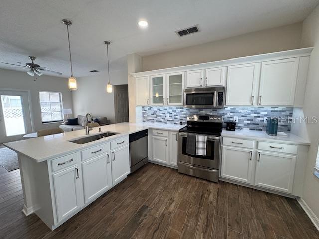 906 Pawstand Road Celebration, FL 34747 - Photo 13 of 29 a kitchen with stainless steel appliances granite countertop a stove top oven a sink dishwasher a refrigerator and a dining table with wooden floor