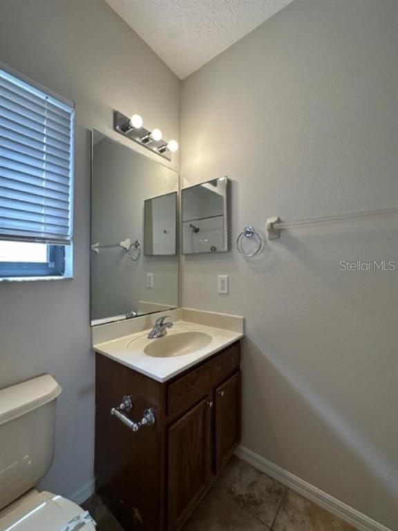 906 Pawstand Road Celebration, FL 34747 - Photo 23 of 29 a bathroom with a sink a toilet a mirror and vanity