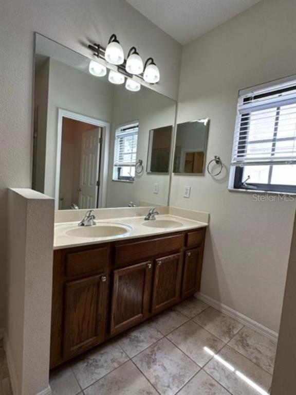 906 Pawstand Road Celebration, FL 34747 - Photo 8 of 29 a bathroom with a double vanity sink and a mirror