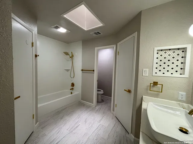 a bathroom with a sink a toilet and shower