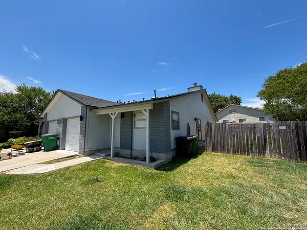a view of a house with a yard and wooden fence