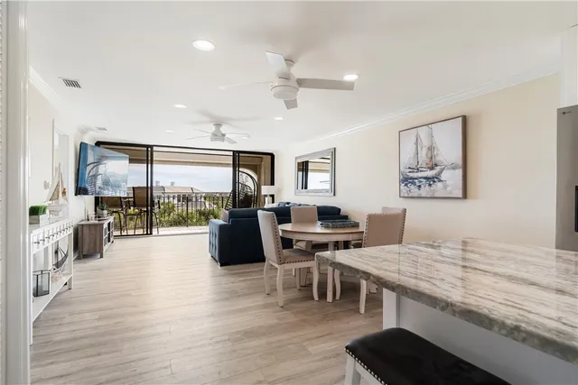 a living room with furniture ceiling fan and a large window