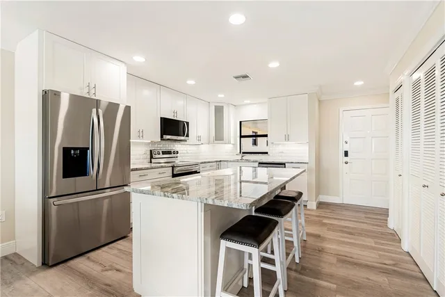 a kitchen with stainless steel appliances a refrigerator stove microwave and cabinets