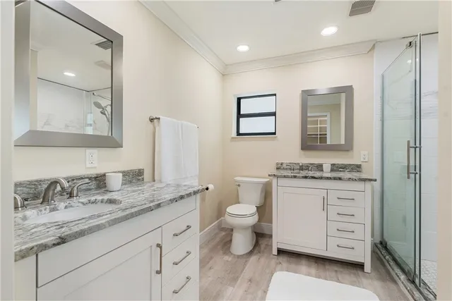 a bathroom with a granite countertop shower sink vanity and mirror