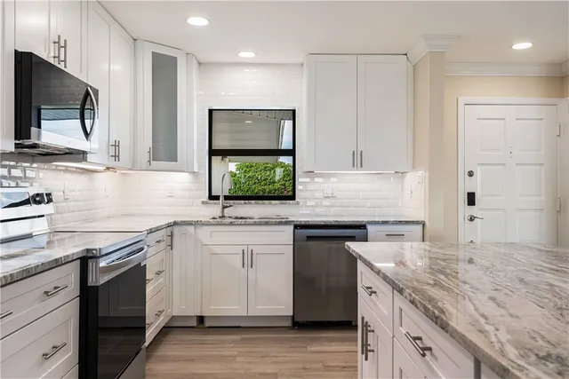 a kitchen with granite countertop white cabinets and white appliances