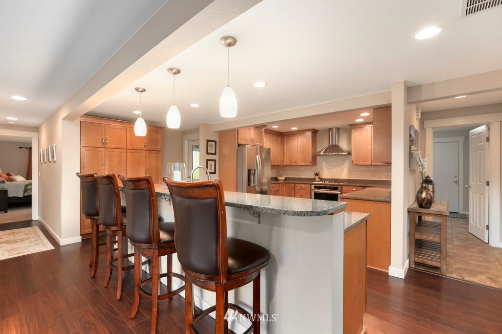 2329 Cedar Road Lake Stevens, WA 98258 - Photo 6 of 40 a kitchen with stainless steel appliances kitchen island granite countertop a table chairs and wooden floor