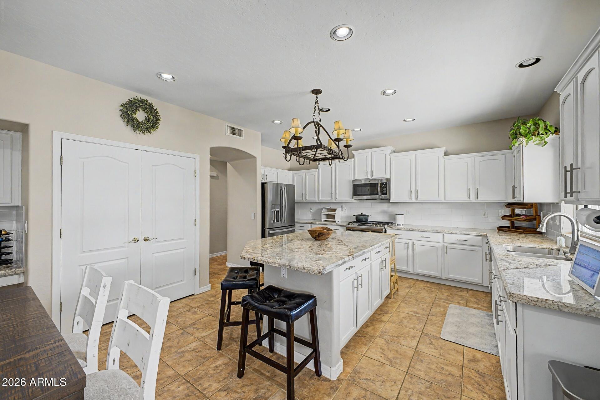 3595 East Latham Way Gilbert, AZ 85297 - Photo 12 of 35 a kitchen with a sink stove and cabinets