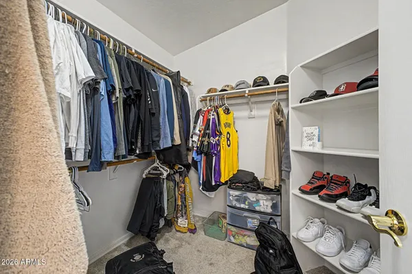 a view of walk in closet with clothes and shoes