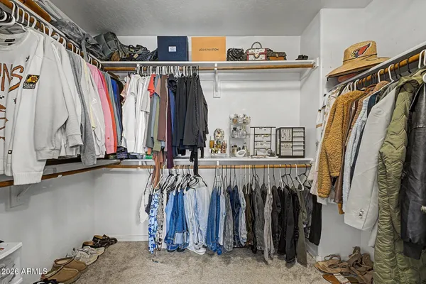 a view of walk in closet with clothes and shoes