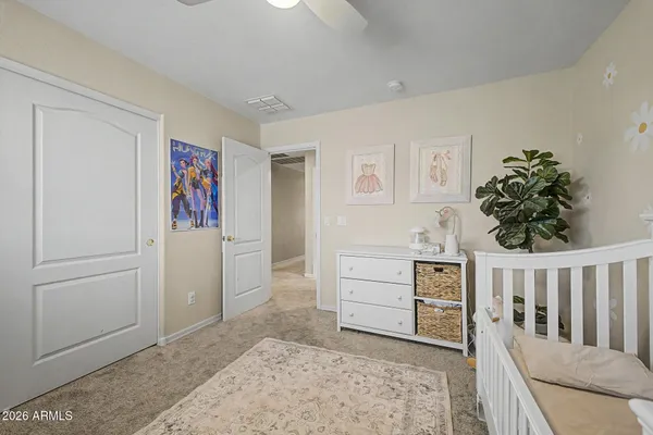 a view of a bedroom with baby crib and furniture